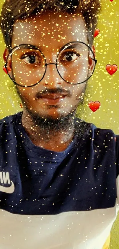 Man in glasses with heart-patterned background.