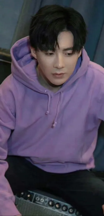 Person wearing a stylish lilac hoodie sitting.