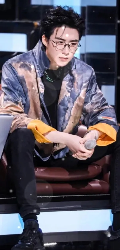 Stylish person with an art-inspired jacket sitting confidently.