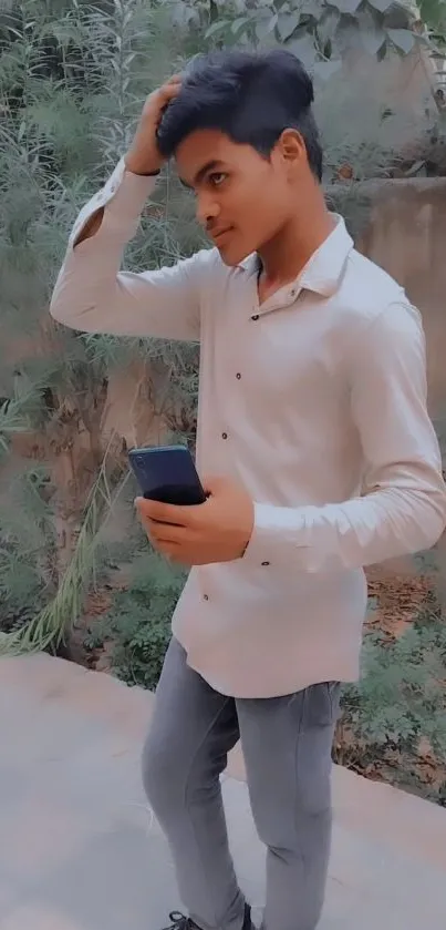 Stylish young man holding phone outdoors.