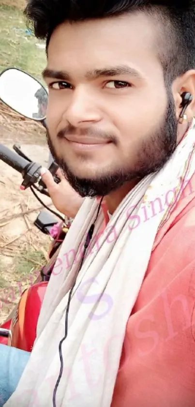 Young man smiling on a bike outdoors.