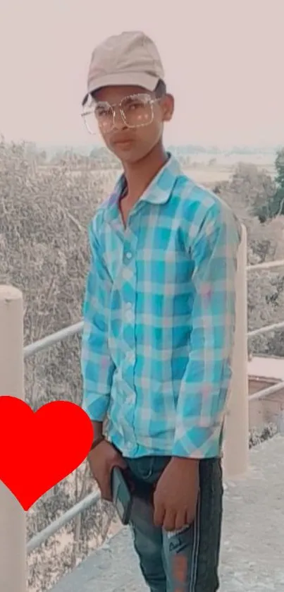 Young man in blue checkered shirt with red heart graphic.