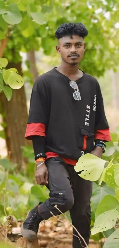 Stylish young man in nature with green leaves.