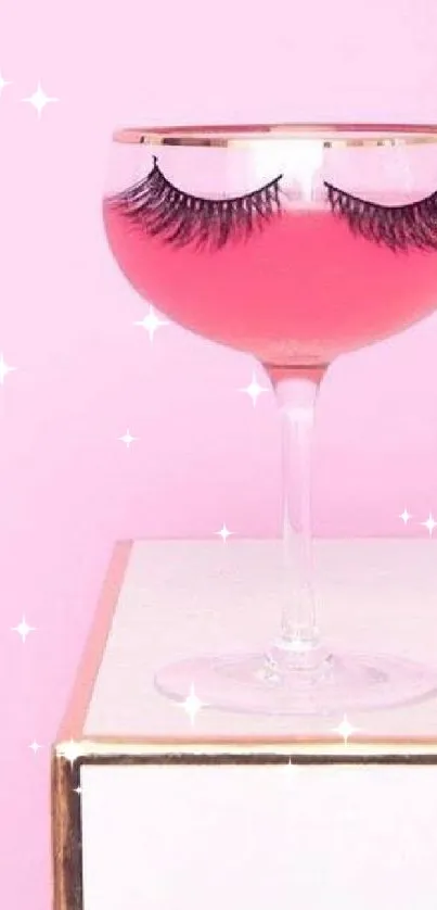 A stylish pink cocktail glass with eyelashes on a minimalist pink background.