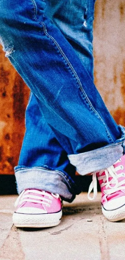 Stylish wallpaper of pink sneakers with rolled denim jeans.