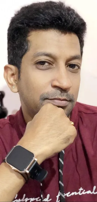 Man wearing maroon shirt with smartwatch.