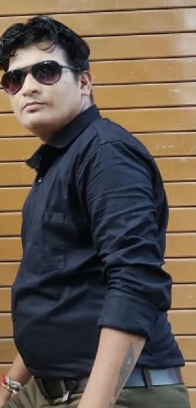 Man in black shirt with sunglasses against a wooden background wallpaper.