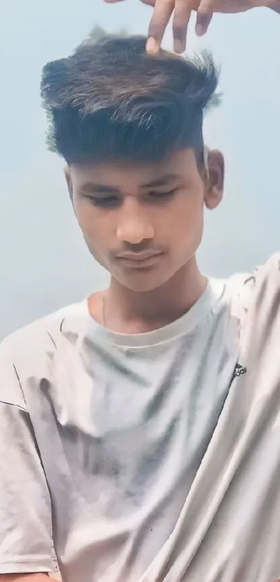 Young man in white shirt with a serene sky backdrop.