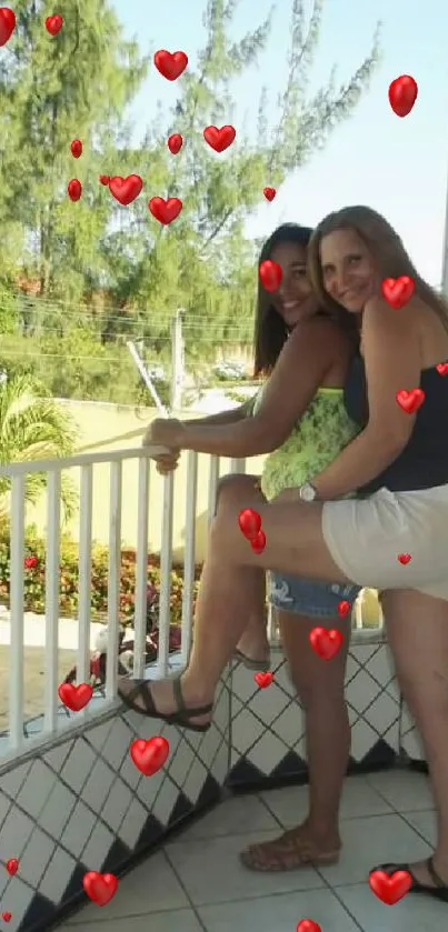 Two friends on a tropical balcony with trees and tiles.