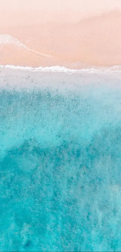 Aerial view of turquoise ocean meeting a sandy beach.