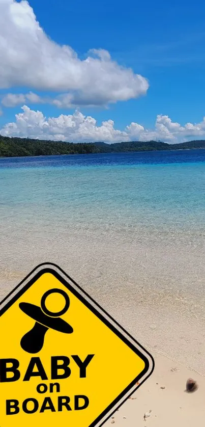 Tropical beach with baby on board sign, clear sky and ocean.