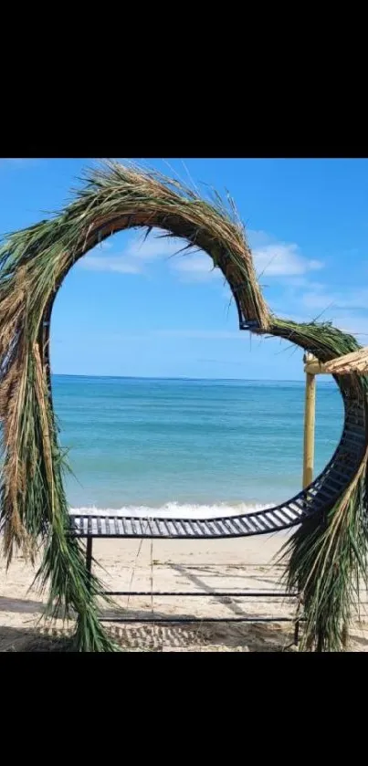 Tropical beach with heart-shaped palm frame and blue ocean.