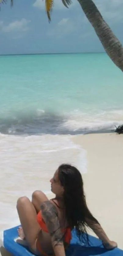 A woman relaxes under a palm tree on a turquoise beach.