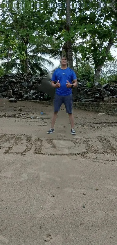 Person standing on a beach with sand art and tropical backdrop.