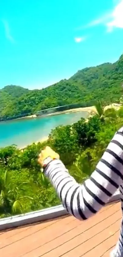 Woman looks over tropical beach with lush hills and blue sky.