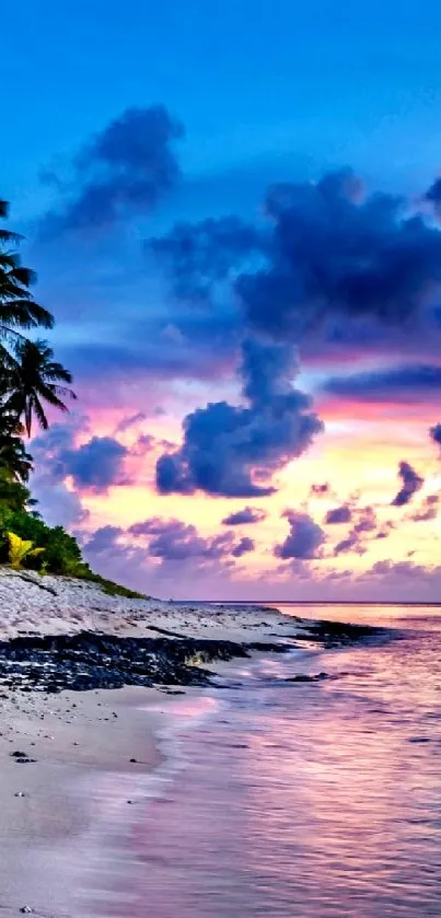 Tropical beach sunset with vibrant sky and ocean waves.