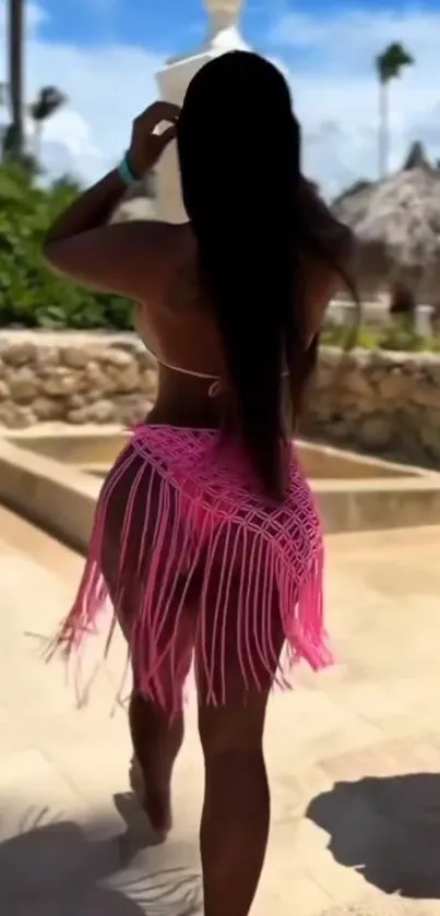 Woman in pink sarong at beachside resort