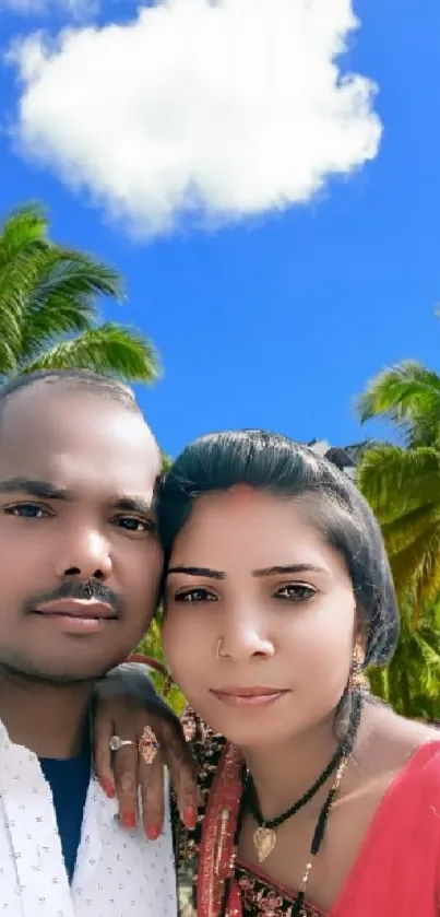 Couple at a tropical beach with palm trees and blue sky.