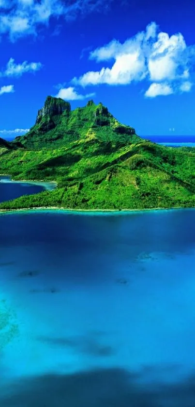 Tropical island with blue ocean and lush green hills under a clear sky.