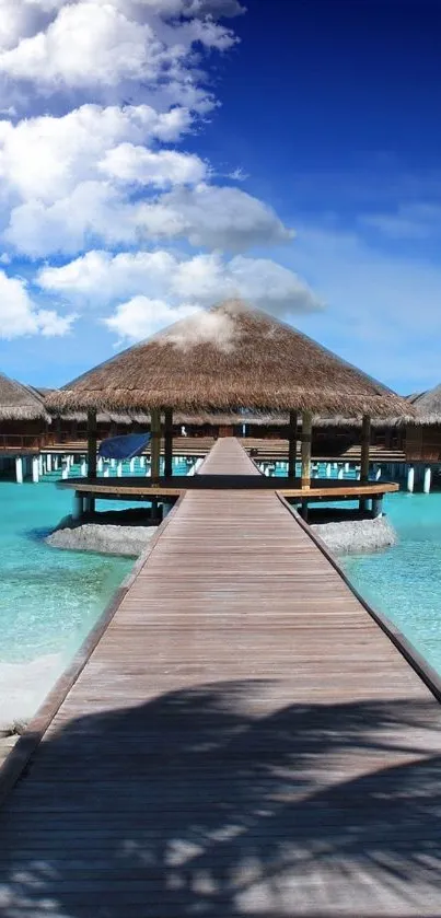 Tropical island view with huts and turquoise water under blue sky.