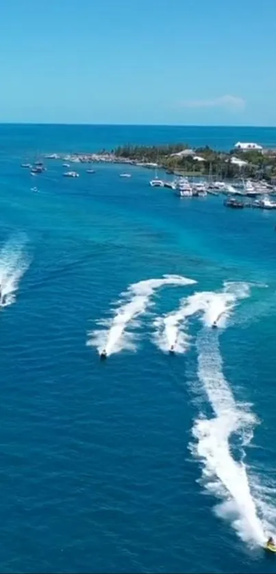 Aerial view of jet skis on vibrant blue ocean near tropical island.