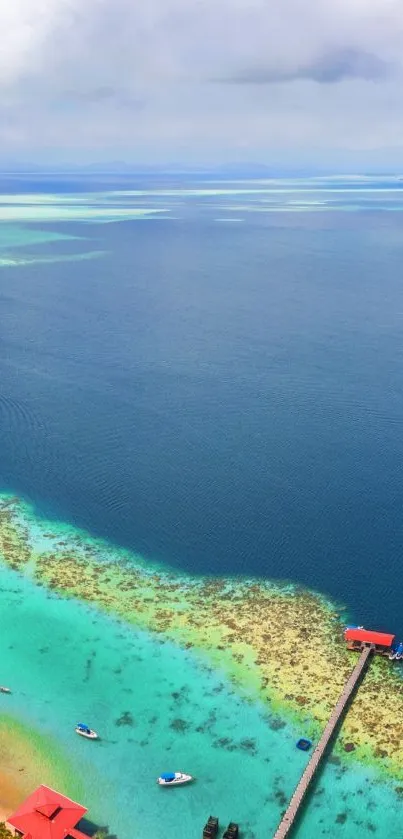 Aerial view of tropical paradise with blue ocean and red-roofed huts.