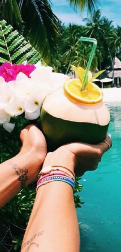 Hands holding coconut drink by turquoise ocean.