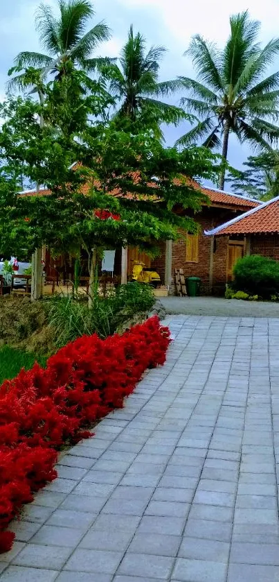 Tropical garden pathway with red flowers and palm trees.