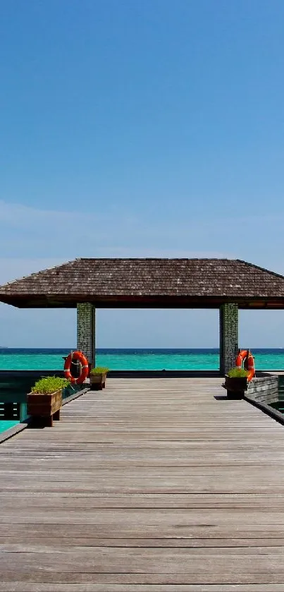 Wooden pier leading to a tropical hut over turquoise ocean water.