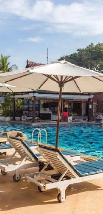 Tropical poolside with loungers and umbrellas under a sunny sky.