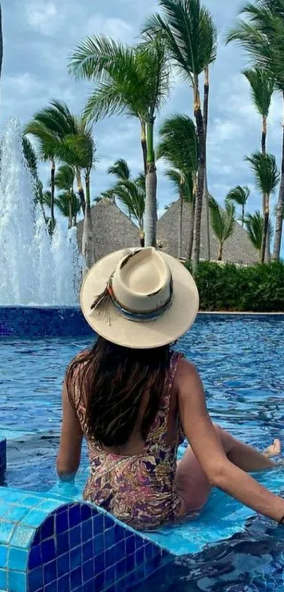 Tropical poolside with a woman in a hat enjoying the serene view.