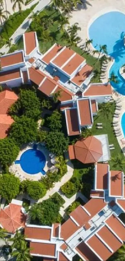 Aerial view of tropical resort with lush greenery and blue swimming pools.