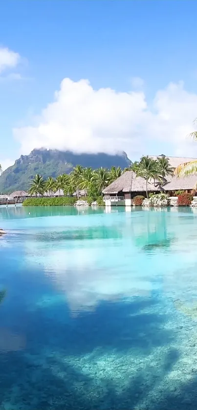 Tropical island with huts, clear blue water, and mountain background.