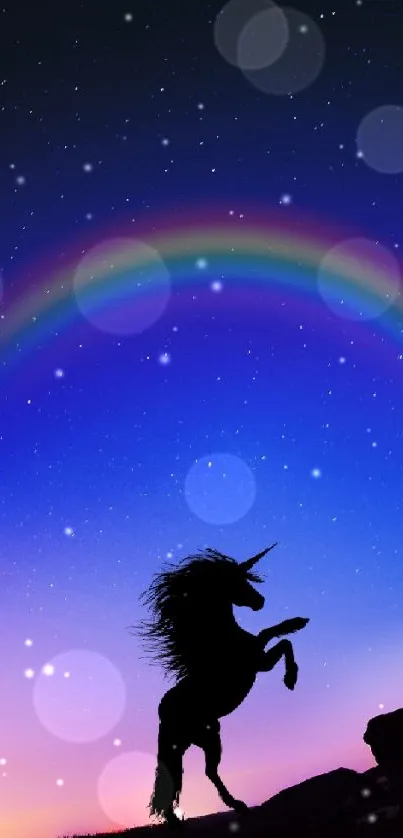 Silhouette of a unicorn under a vibrant night sky with a rainbow.