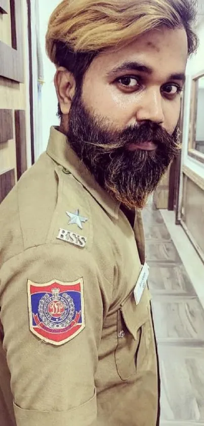 Uniformed man with beard in a corridor setting.