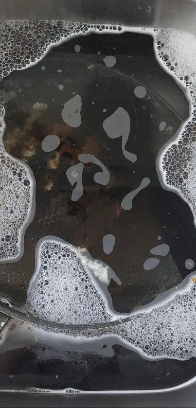 Aesthetic shot of a kitchen sink with soapy water and foam.