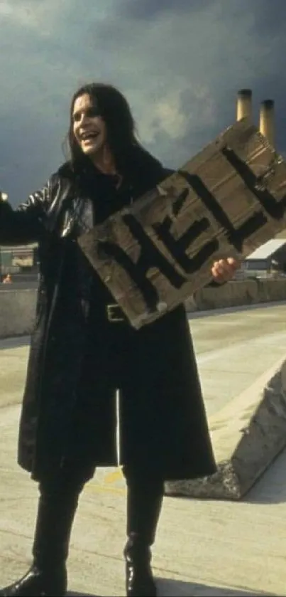 Person in black coat hitchhiking with a sign.