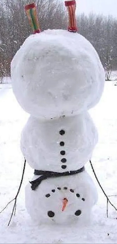 Playful snowman standing upside down in the snow.