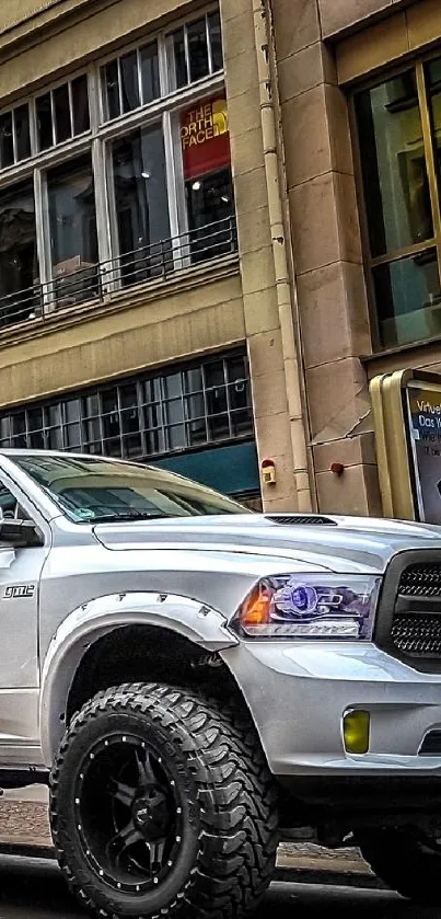 White pickup truck on city street with urban buildings.