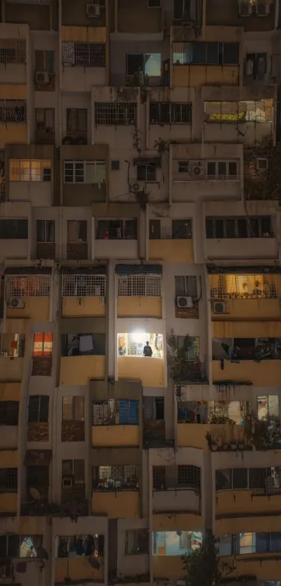 Night view of an apartment building with illuminated windows.