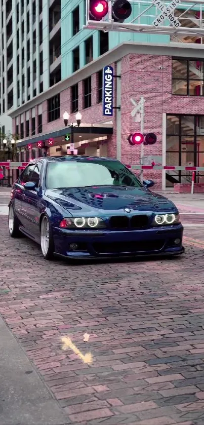 Blue car on a brick road in an urban cityscape backdrop.