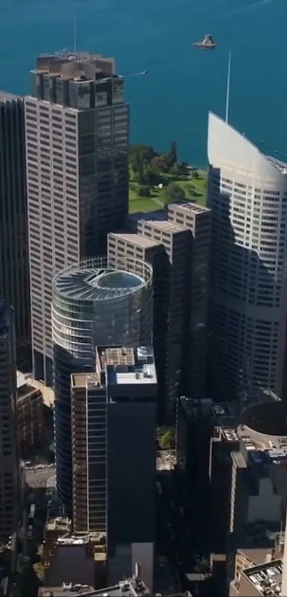 Aerial view of tall skyscrapers by the waterfront under a clear blue sky.