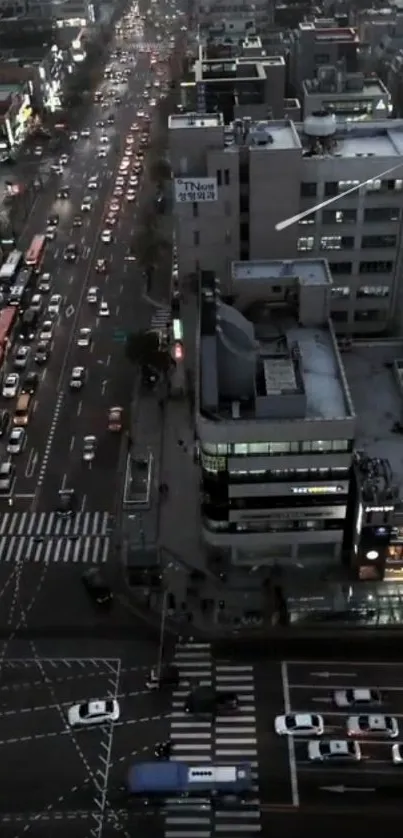 Aerial night view of a bustling city street with glowing headlights.