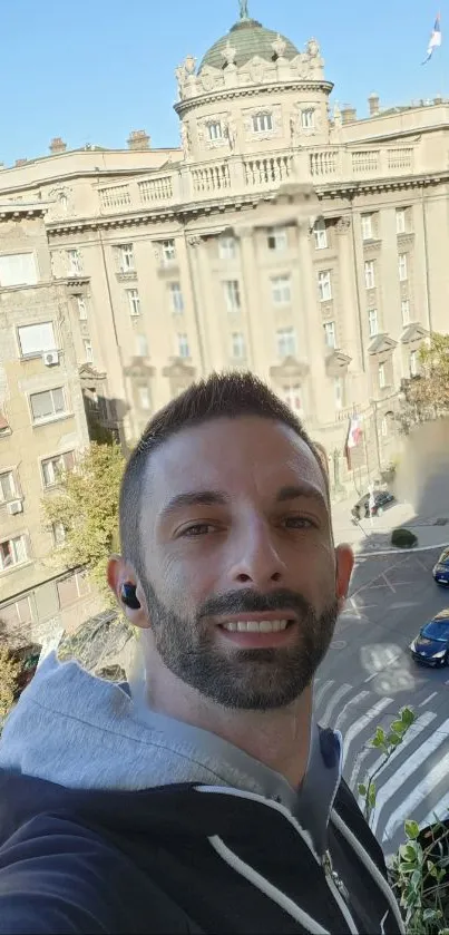 Selfie with urban cityscape and historical building in the background.