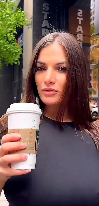 Woman holding coffee in urban setting