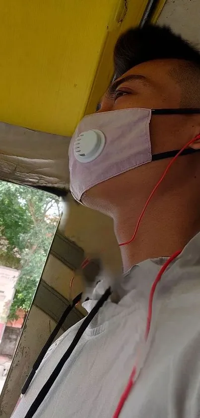 Young person with mask and earphones on public transport.