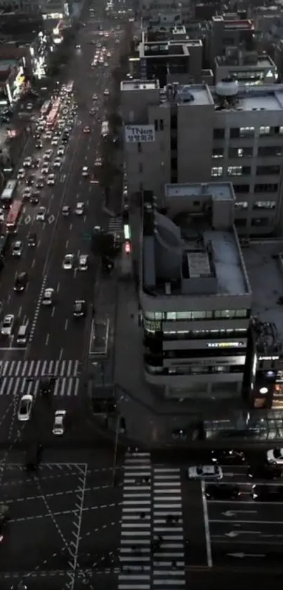 Aerial view of city streets at dusk with vibrant traffic and buildings.