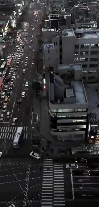 Arial view of city streets at night with illuminated buildings and traffic.