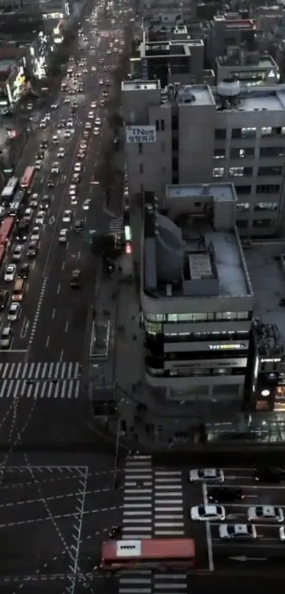 Aerial view of city streets at night with illuminated buildings.