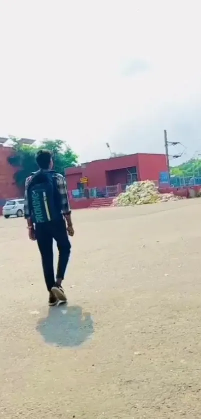 Person walking in urban plaza with backpack, bright sky.